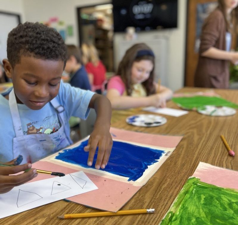Two elementary students painting in art class